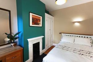 a bedroom with a white bed and a green wall at Tastefully Decorated 1-Bed with Free Parking - At Hem in Winchester