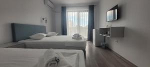 a hotel room with two beds and a window at Vila Ame Eforie Nord in Eforie Nord