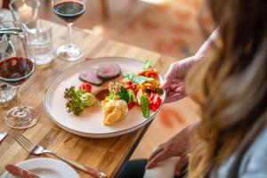 uma mulher sentada numa mesa com um prato de comida em Diehls Hotel em Koblenz