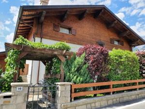 una casa in legno con una recinzione di fronte ad essa di Casa Grafa Bormio a Valdisotto