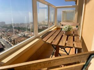 - une table en bois sur un balcon avec vue sur la ville dans l'établissement Apartamento Catania en Aguadulce con vistas al mar, à Aguadulce