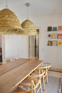 una sala da pranzo con tavolo e sedie in legno di Beach house upscale villa with pool a Costa da Caparica