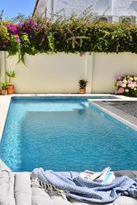 una piscina accanto a un edificio fiorito di Beach house upscale villa with pool a Costa da Caparica