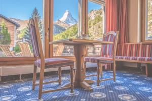 a table and chairs with a view of a mountain at Antares Hotel in Zermatt