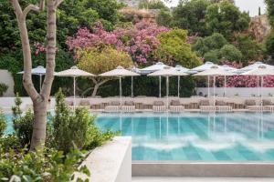 uma piscina com cadeiras e guarda-sóis em Lindos Mare, Seaside Hotel em Líndos