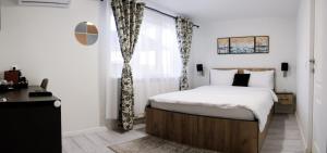 een slaapkamer met een bed en een raam bij Casa Bella in Hunedoara