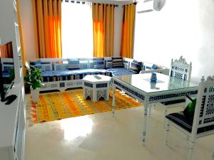 a living room with a glass table and a couch at Cosy Appart - Central & Near main interest points in La Marsa