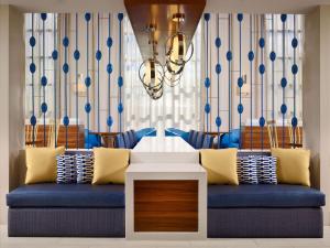 un soggiorno con divano blu e lampadario pendente di Sonesta ES Suites Houston Galleria a Houston