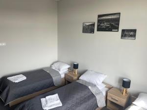 twee bedden in een kamer met foto's aan de muur bij AQUARA Radomsko in Radomsko