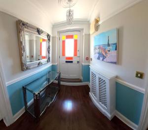 un pasillo con paredes azules y blancas y una puerta en Beautifully appointed, period seaside apartment, en Folkestone