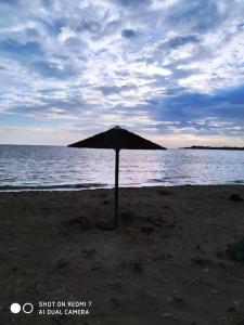 um guarda-sol sentado na praia perto da água em Grecos apartment em Preveza