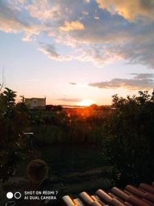 uma vista para o pôr-do-sol a partir de uma janela de uma casa em Grecos apartment em Preveza