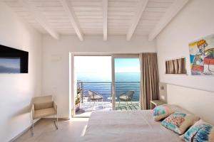 una camera con letto e vista sull'oceano di Hotel Caramare a Cala Gonone