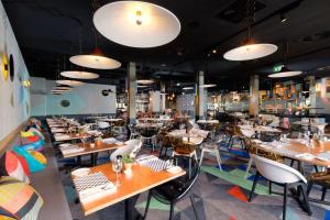 a restaurant with tables and chairs and lights at Atura Albury in Albury