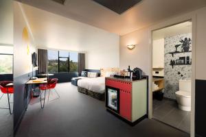 a hotel room with a king sized bed and a bathroom at Atura Albury in Albury