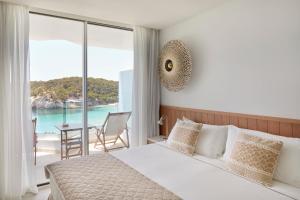 um quarto com uma cama e vista para o oceano em Meliá Cala Galdana em Cala Galdana