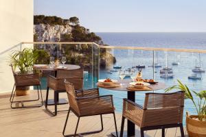 uma mesa numa varanda com vista para o oceano em Meliá Cala Galdana em Cala Galdana