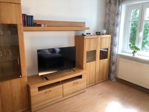 een groot houten entertainmentcentrum met een flatscreen-tv bij Sandstein-Ferien, FeWo "Biela", gemütlich, zentral, ruhig, Terrasse, Familienfreundl in Königstein an der Elbe