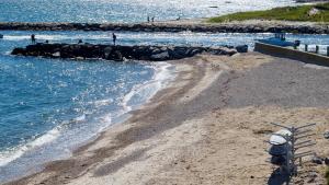 a sandy beach with people walking on the water at Falmouth Tides in Falmouth