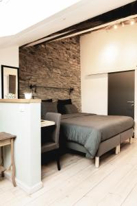 a bedroom with a bed and a stone wall at Il était une fois in Herbeumont