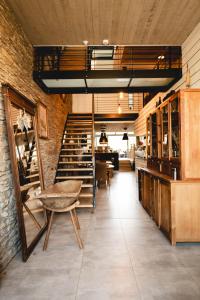 a room with a staircase and a table and chairs at Il était une fois in Herbeumont