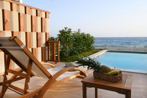 Villa Dorra Coast Suites في كانالي: كرسي وسلة فواكه بجانب مسبح