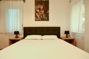 Thessaloniki Center Comfortable Apartment في سلانيك: غرفة نوم بسرير ابيض كبير مع طاولتين