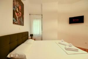 Thessaloniki Center Comfortable Apartment في سلانيك: غرفة نوم عليها سرير وفوط بيضاء