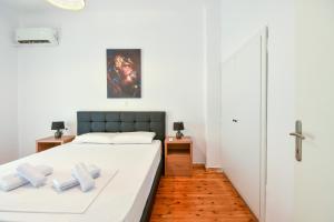 Thessaloniki Center Comfortable Apartment في سلانيك: غرفة نوم بسرير ذو شراشف بيضاء ومخدات بيضاء