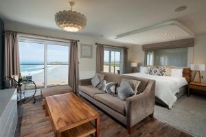 una camera con letto e divano e vista sull'oceano di Fistral Beach Hotel and Spa - Adults Only a Newquay