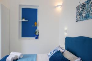 een kamer met een blauw raam en een blauwe stoel bij Residence Buonocore in Amalfi