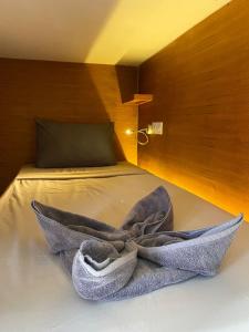 Una cama con una toalla encima. en Kaniu Capsule Hostel, en Kuta Lombok