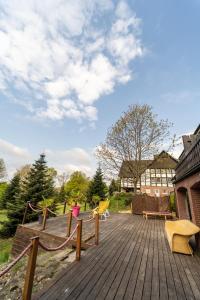 eine Holzterrasse mit gelben Stühlen und einem Gebäude in der Unterkunft Hotel Niedersächsischer Hof in Bad Bentheim