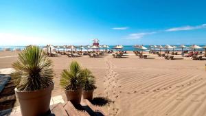 einen Strand mit Liegestühlen und Sonnenschirmen und dem Meer in der Unterkunft Beach Walk Apartments in Ulcinj