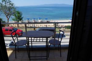 d'une table et de chaises sur un balcon avec vue sur la plage. dans l'établissement Seafront Centre Ouranoupoli, à Ouranoupoli