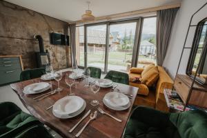 una sala da pranzo con tavolo in legno e bicchieri da vino di Tatry Zachodnie a Witów