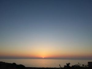 een zonsondergang boven het water met de zon in de lucht bij Casa Vacanza Portu Maga (Marina di Arbus-Sardegna) in Portu Maga