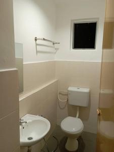 La salle de bains est pourvue de toilettes, d'un lavabo et d'une fenêtre. dans l'établissement CH Budget Hotel, à Cameron Highlands