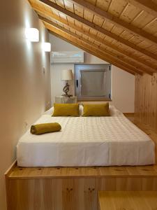 a bedroom with a large bed with yellow pillows at Apartamento Férias (Apartamento Norte) in Costa Nova