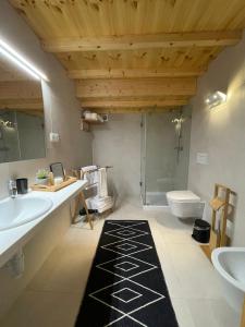 a bathroom with two sinks a toilet and a shower at Apartamento Férias (Apartamento Norte) in Costa Nova