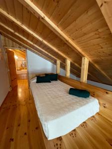 a large bed in a room with a wooden ceiling at Apartamento Férias (Apartamento Norte) in Costa Nova