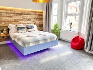 um quarto com uma cama e uma parede de madeira em Cloud9 Guest House - by Coastline Retreats - Newly Renovated, Beautiful Ensuite Rooms Near Seafront in Town Centre, Netflix, SuperFast WiFi, Communal Kitchen em Bournemouth