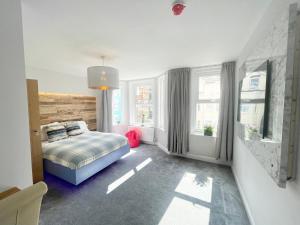 um quarto com uma cama e duas janelas em Cloud9 Guest House - by Coastline Retreats - Newly Renovated, Beautiful Ensuite Rooms Near Seafront in Town Centre, Netflix, SuperFast WiFi, Communal Kitchen em Bournemouth