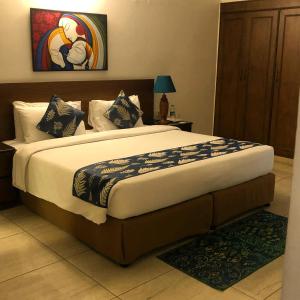 ein Schlafzimmer mit einem großen Bett in einem Zimmer in der Unterkunft The Neem in Neu-Delhi