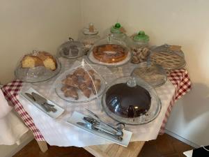 una mesa con diferentes tipos de pasteles. en Agriturismo Poderedodici, en Orbetello