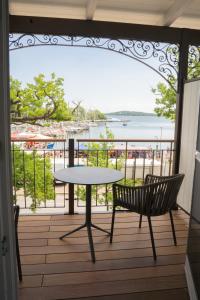 una mesa y sillas en un balcón con vistas al agua en Hafenhotel zu Putbus, en Putbus