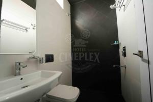 a bathroom with a sink and a toilet and a mirror at Hotel Cineplex in Coimbatore