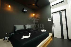 a bedroom with a black bed with a swan on it at Hotel Cineplex in Coimbatore