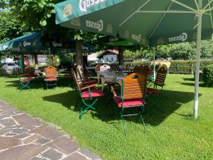 une table et des chaises sous un parasol dans l'herbe dans l'établissement Hotel Senningerbräu, à Bramberg am Wildkogel