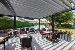 patio ze stołami i krzesłami oraz basenem w obiekcie Le Grand Hotel & Spa w mieście Gérardmer